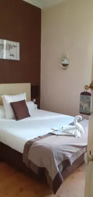 a bedroom with a large white bed with a swan on it at Auberge Du Parc in Orgon