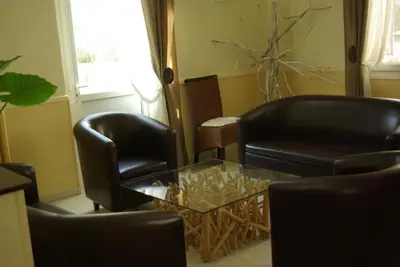 a living room with two chairs and a glass table at Auberge Du Parc in Orgon