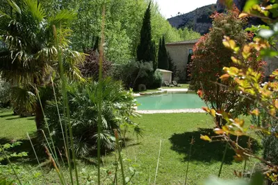 a garden with a swimming pool in a yard at Auberge Du Parc in Orgon