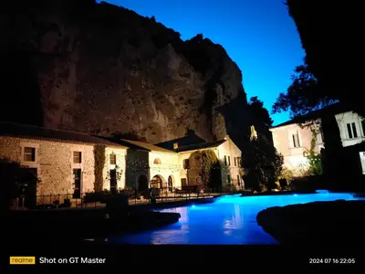 a group of buildings in front of a mountain at night at Auberge Du Parc in Orgon