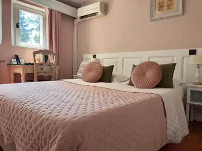 a bedroom with a large white bed with pink pillows at Logis Hotel le Mas De Cure Bourse in LʼIsle-sur-la-Sorgue