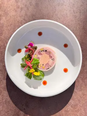 a white plate with food on a table at Logis Hotel le Mas De Cure Bourse in LʼIsle-sur-la-Sorgue