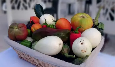 a basket of fruits and vegetables on a table at Logis Hôtel Restaurant du Parc in Fontaine-de-Vaucluse