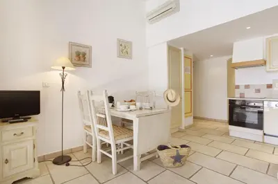 a kitchen with a table and a desk with a lamp at Résidence Odalys La Bastide des Chênes in Gordes