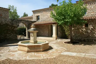 a large stone fountain in front of a building at Résidence Odalys La Bastide des Chênes in Gordes