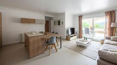 a kitchen and living room with a table and a couch at Le Cigalou in Mallemort