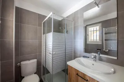 a bathroom with a toilet and a sink and a mirror at Le Cigalou in Mallemort