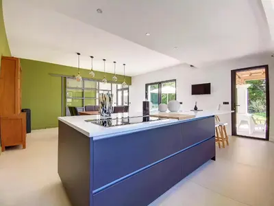 an open kitchen with a blue island in the middle at Villa de prestige 10 personnes à Eyragues in Eyragues