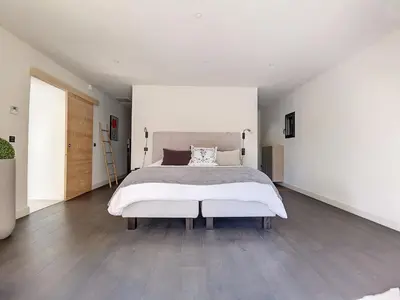 a white bedroom with a large bed and wooden floors at Villa de prestige 10 personnes à Eyragues in Eyragues