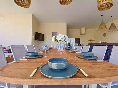 a wooden table with plates and wine glasses on it at Villa de prestige 10 personnes à Eyragues in Eyragues