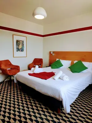 a red building with the sign for a modern hotel at La Maison des Ocres - Provence in Roussillon
