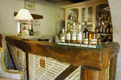 a bar with a lot of bottles of alcohol at Hostellerie Le Roy Soleil in Ménerbes