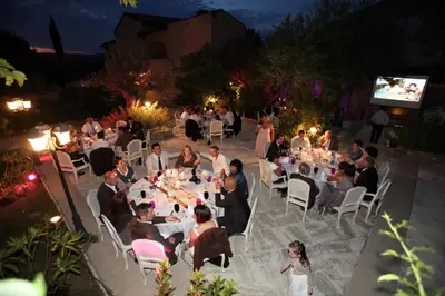 a group of people sitting at tables at a party at Hostellerie Le Roy Soleil in Ménerbes