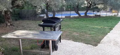 a grill sitting on a table in a yard at Maison le Pastaga in Caromb