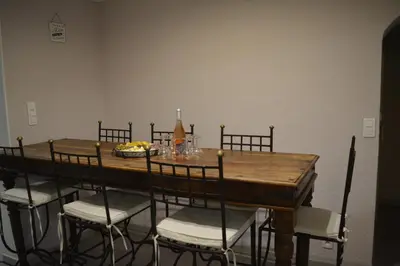 a dining room table with chairs and a bottle of wine at Maison le Pastaga in Caromb
