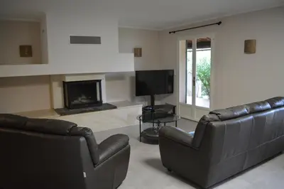 a living room with two leather couches and a television at Maison le Pastaga in Caromb