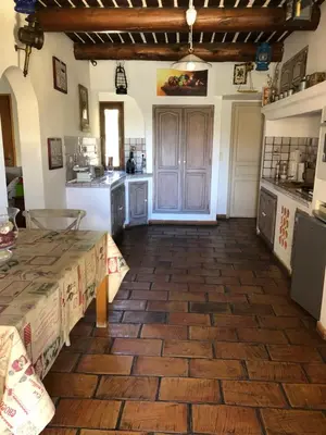 a large kitchen with a wooden floor and a table at Villa dans le LUBERON à 2 km de LOURMARIN in Lauris