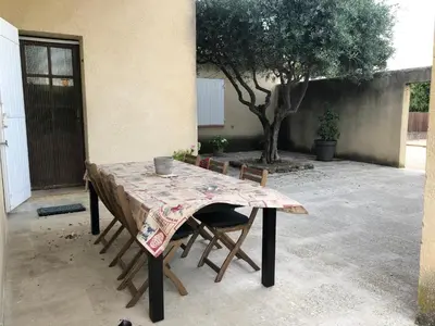 a table with chairs and a table cloth on it at Villa dans le LUBERON à 2 km de LOURMARIN in Lauris