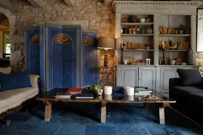 a living room with a table and a couch at La Bastide de Marie, Maisons et Hôtels Sibuet in Ménerbes