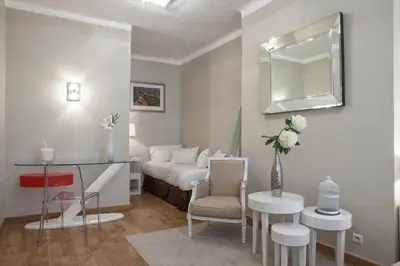 a bedroom with a bed and a table and a chair at Hôtel de France in Aix-en-Provence