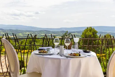 a white table with wine glasses and food on it at Mas des Herbes Blanches Hôtel & Spa – Relais & Châteaux in Joucas