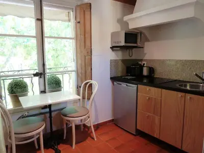 a kitchen with a sink and a table with chairs at Appartement Cours Mirabeau CrsMb in Aix-en-Provence
