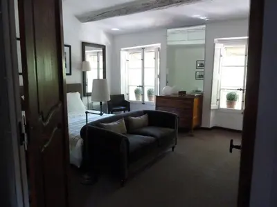 a bedroom with a bed and a couch and windows at Appartement Cours Mirabeau CrsMb in Aix-en-Provence