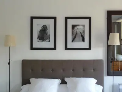 a bedroom with three framed pictures above a bed at Appartement Cours Mirabeau CrsMb in Aix-en-Provence