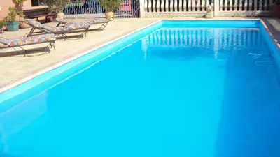 a swimming pool with two lounge chairs next to it at Maison d'Hôtes La Douloire in Pernes-les-Fontaines
