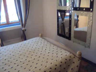 a bed in a room with a mirror at Maison d'Hôtes La Douloire in Pernes-les-Fontaines