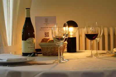 a table with three wine glasses and a bottle of wine at Logis Hotel Le Blason de Provence in Monteux