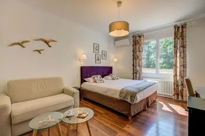 a bedroom with a bed and a couch and a table at Logis Hotel Le Blason de Provence in Monteux