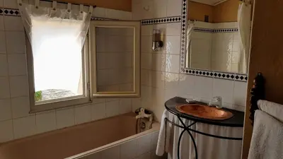a bathroom with a sink and a tub and a window at Mas du Kairos in Venasque
