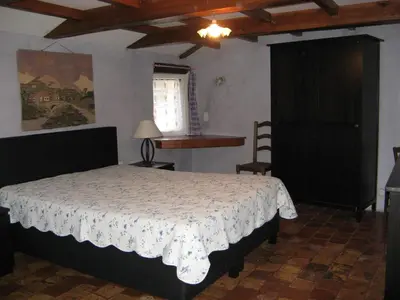 a bedroom with a bed and a table and a window at Gîte de caractère au pied du Mont Ventoux avec piscine couverte in Sault-de-Vaucluse
