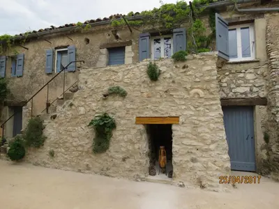 an old stone building with a door and a window at Gîte de caractère au pied du Mont Ventoux avec piscine couverte in Sault-de-Vaucluse