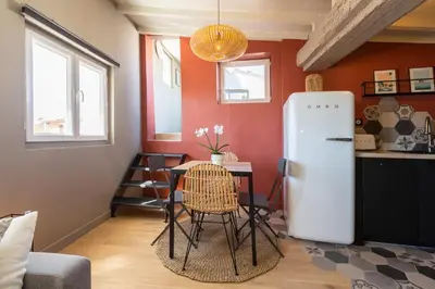 a kitchen with a table and a refrigerator in a room at DUPLEX MIRABEAU - Roof terrace with panoramic view in Aix-en-Provence