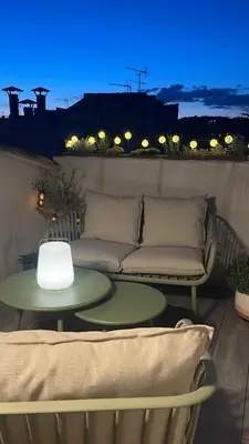 a couch and a table on a balcony at night at DUPLEX MIRABEAU - Roof terrace with panoramic view in Aix-en-Provence