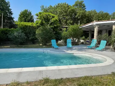 a swimming pool with blue chairs in a yard at Villa Camille in Céreste