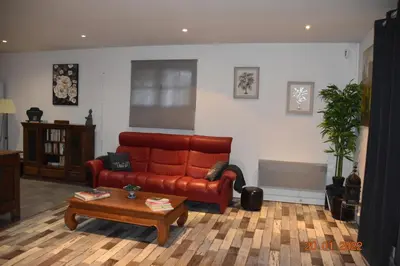 a living room with a red couch and a coffee table at Villa Lumières in Goult