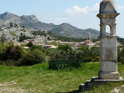 a monument in a field with mountains in the background at Vacation rental in the Alpilles, Provence, close to the village center - Beautiful view -Air conditionning Heated pool and spa - sleeps 8 in Aureille