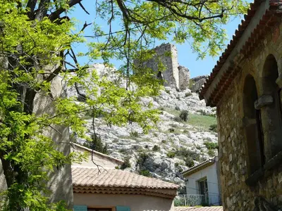 a castle on top of a hill with houses at Vacation rental in the Alpilles, Provence, close to the village center - Beautiful view -Air conditionning Heated pool and spa - sleeps 8 in Aureille