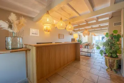 a lobby with a reception desk and pendant lights at Hôtel Le Pré Saint Michel in Manosque