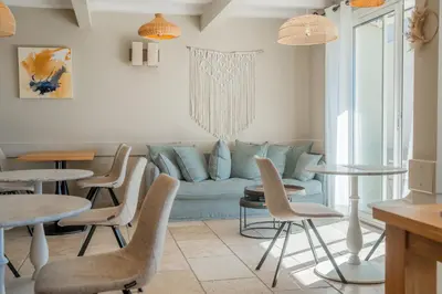 a living room with a couch and tables and chairs at Hôtel Le Pré Saint Michel in Manosque