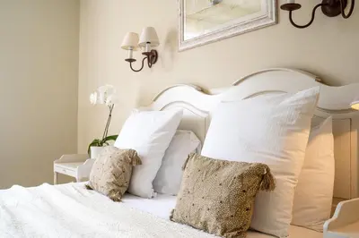 a bedroom with a white bed with white pillows at Hôtel Le Pré Saint Michel in Manosque