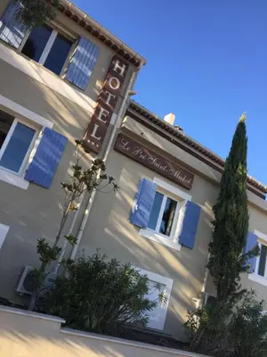 a large white building with blue shuttered windows at Hôtel Le Pré Saint Michel in Manosque