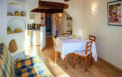 a dining room with a white table and chairs at Cozy Apartment In Villes Sur Auzon in Villes-sur-Auzon