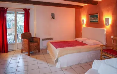 a bedroom with a bed and a chair and a window at Cozy Apartment In Villes Sur Auzon in Villes-sur-Auzon