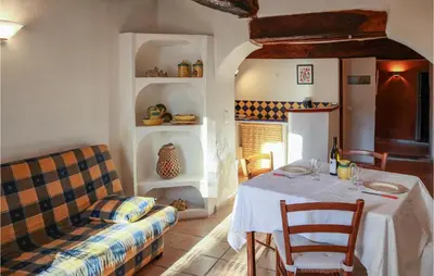 a dining room with a table and a couch at Cozy Apartment In Villes Sur Auzon in Villes-sur-Auzon