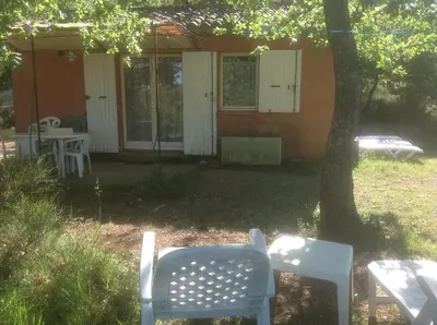 a house with white chairs and a table and a tree at Gite des Ocres in Villars