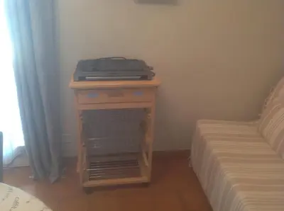 a small table with a laptop on it next to a bed at Gite des Ocres in Villars
